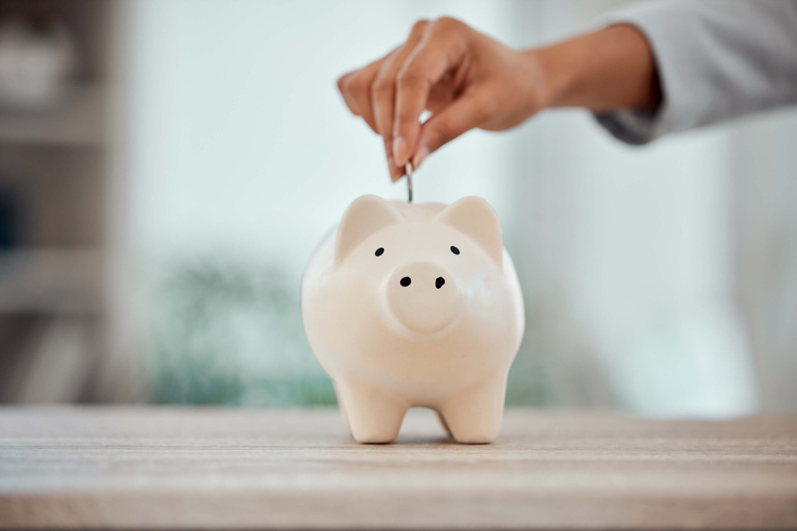 Beneficios de la depilación laser ahorra de tiempo dinero - Persona ahorrando dinero en una alcancía de cerdito