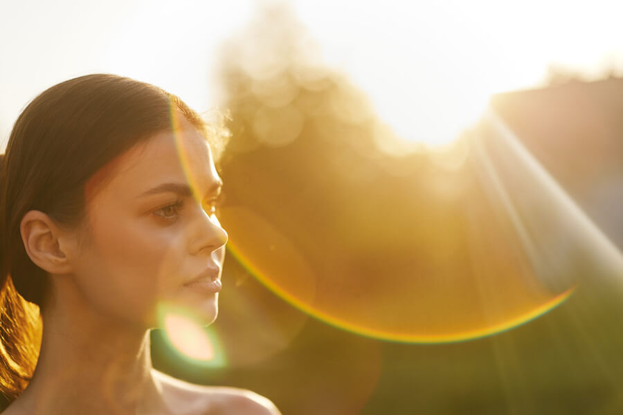 Beneficios del Botox - Mujer contemplando al atardecer con luz solar intensa al fondo