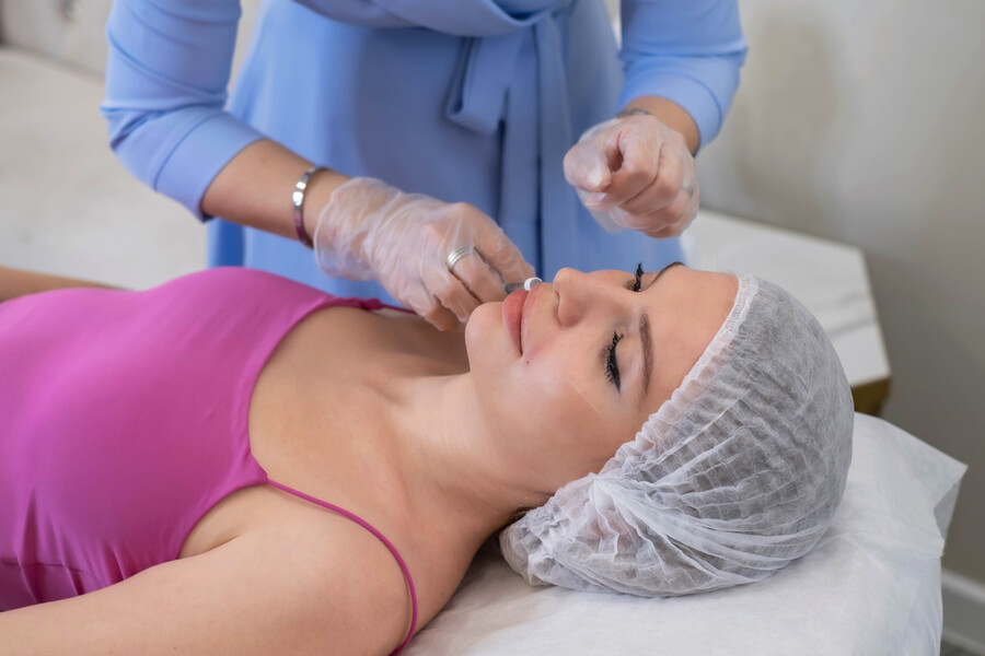 Bioestimulador sculptra que es - Mujer recibiendo tratamiento facial en un centro estético