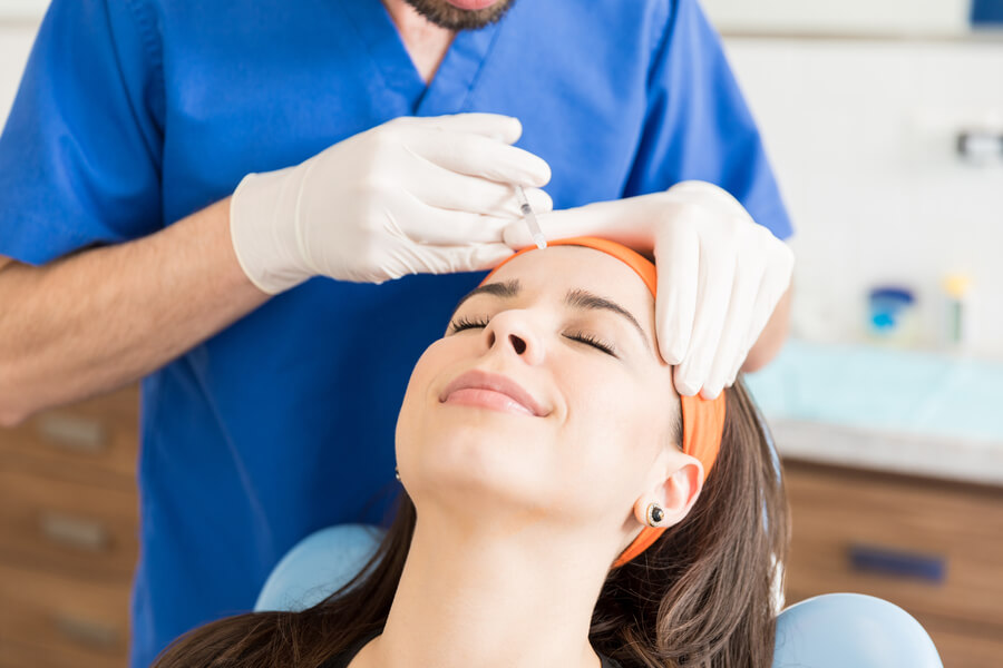 Bioestimulador sculptra recomendaciones - Mujer recibiendo tratamiento estético facial con inyección