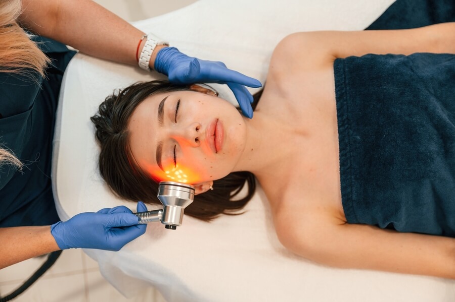 Láser CO2 Fraccionado Cómo Funciona emision - Mujer recibiendo tratamiento facial con luz LED