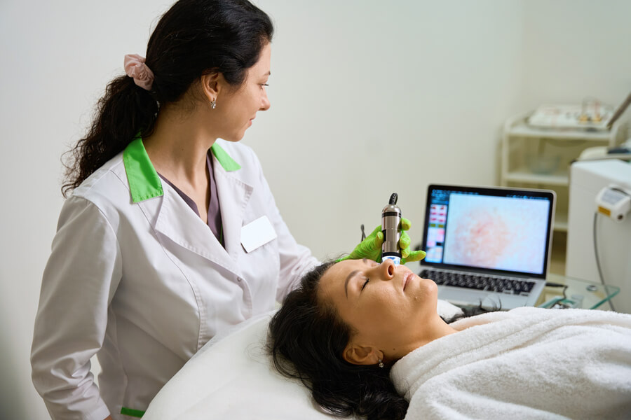 Láser CO2 Fraccionado Cómo Funciona preparacion - Especialista realizando tratamiento facial con equipo dermatológico