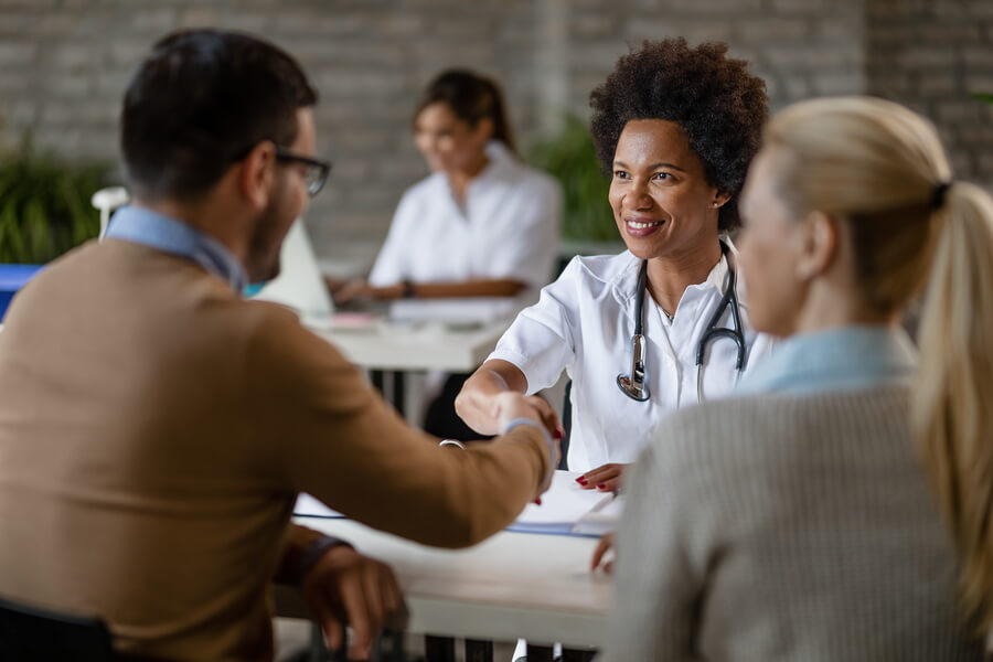 Radiesse Qué es efectos - Doctora saludando a pacientes durante una consulta médica.