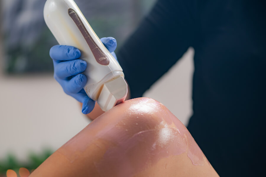 Depilación con láser bikini como funciona - Profesional aplicando tratamiento estético en pierna con dispositivo láser.