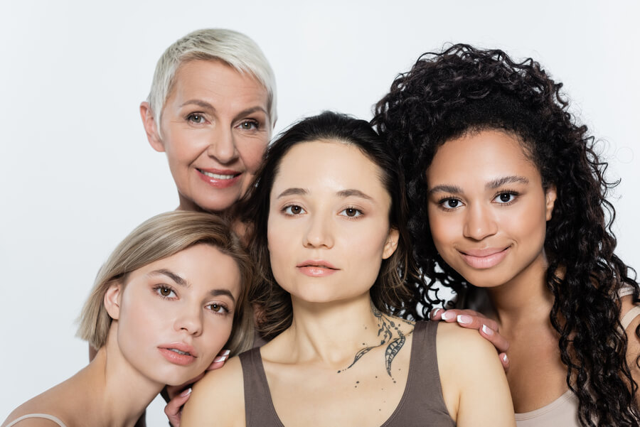 Harmonyca tratamiento facial testimonios - Grupo de cuatro mujeres de diferentes edades y estilos, con fondo blanco