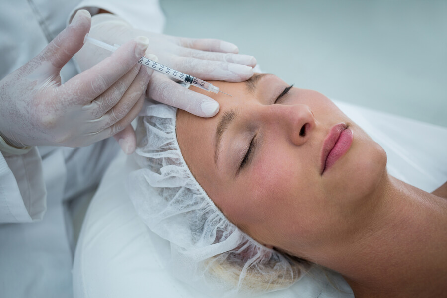Nctf que es beneficios - Aplicación de inyección estética en la frente de una mujer recostada
