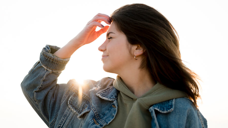 Nctf que es recomendaciones - Mujer con chaqueta de mezclilla mirando al horizonte al atardecer.