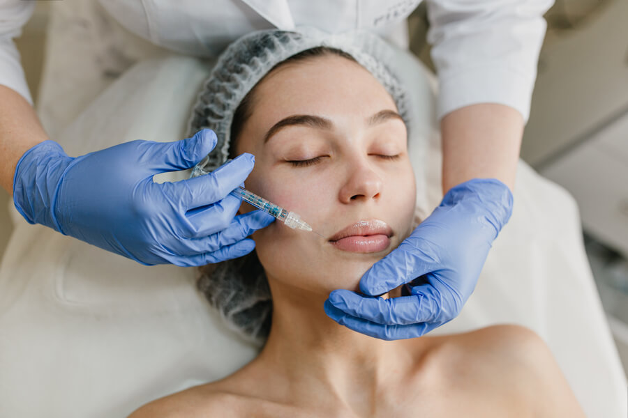 Nctf que es - Mujer recibiendo tratamiento facial con rodillo por profesional con guantes azules
