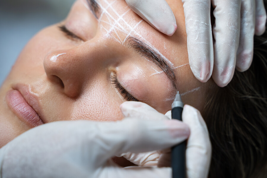 Que es micropigmentacion de cejas - Diseño de cejas con marcaciones blancas realizado por profesional con guantes