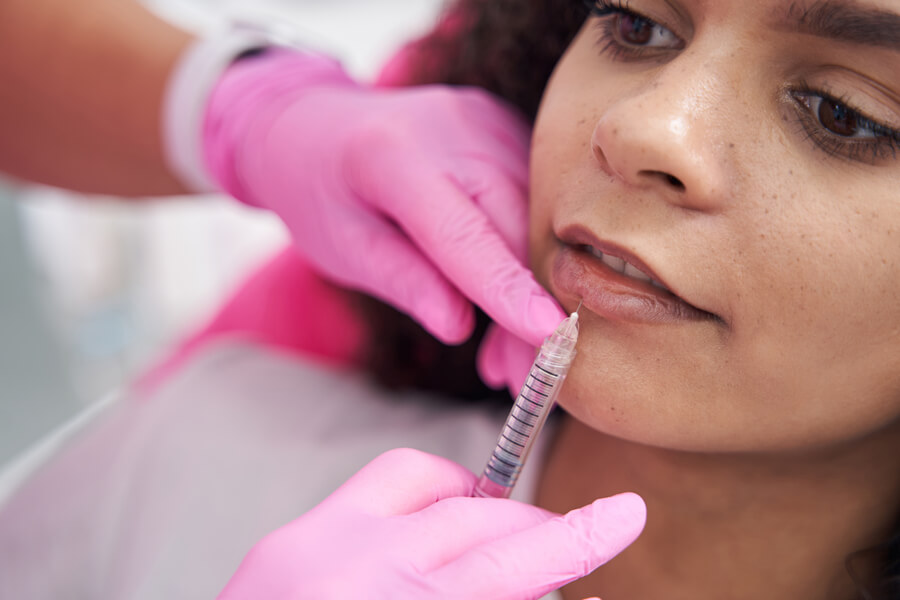 Skin booster como funciona diferencias - Mujer recibiendo una inyección estética en los labios.