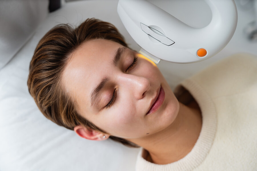 laser co2 fraccionado antes y después cuidados - Mujer recibiendo tratamiento facial con dispositivo de luz pulsada.

