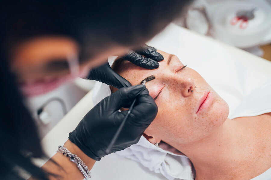 Micropigmentación de cejas pelo a pelo duración - Aplicación de tinte para cejas en cabina estética.