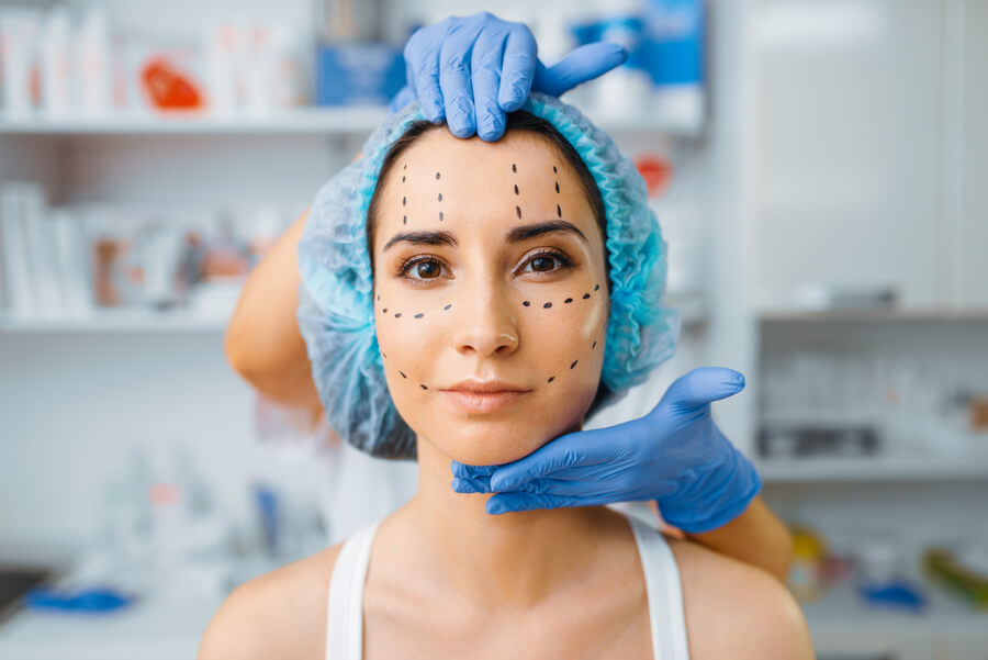 Que es bótox beneficios - Mujer con marcas quirúrgicas en el rostro siendo evaluada por un especialista con guantes azules.

