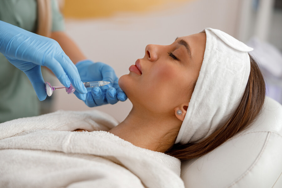 Paciente recibe tratamiento estético facial con dispositivo especializado.